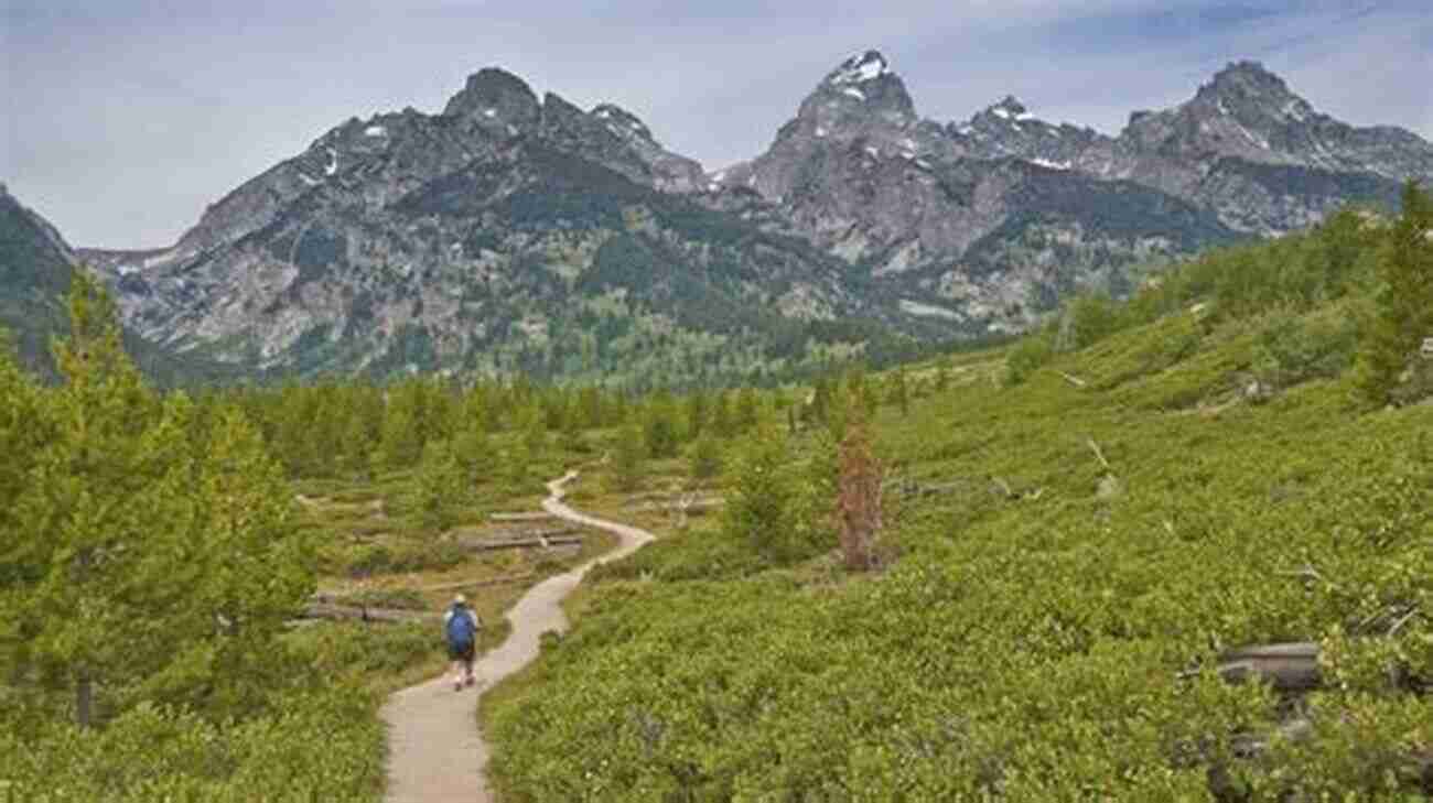 Hiker On A Trail With Grand Teton Mountain Range In The Background Grand Teton National Park Travel Guide With 100 Landscape Photos